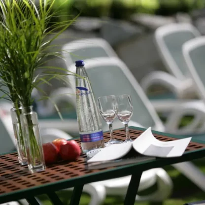Tisch mit Wasserflasche und Gläsern vor Liegen