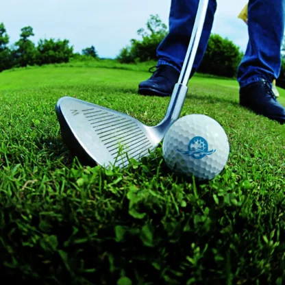 Golfball und Schläger mit Füßen im Hintergrund